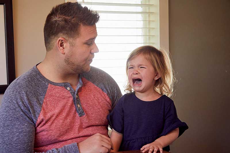 dad talking to toddler having tantrum